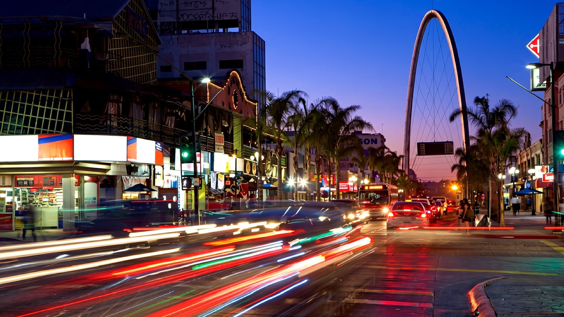 La avenida Revolución de Tijuana al anochecer, con el arco iluminado.